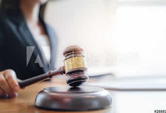 Gavel striking a sound block at a legal or administrative meeting.