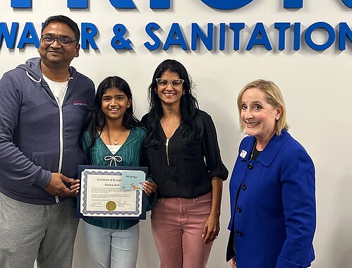 Triunfo Water & Sanitation District team with award recipient holding certificate in office.